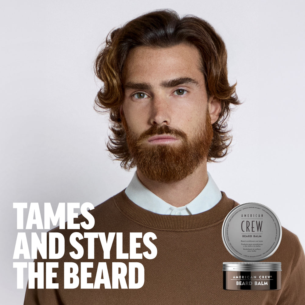 Model Pablo Sobrino is sporting a full beard, wearing a brown sweater with an overlay of American Crew Beard Balm next to the text "Tames and styles the beard". 