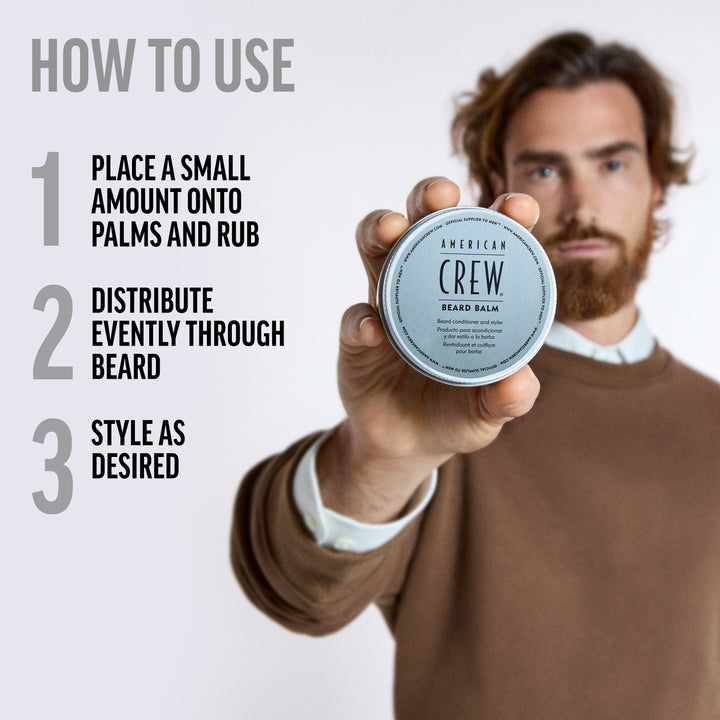Model Pablo Sobrino holding a jar of American Crew Beard Balm with usage instructions text on a white background. Text says the following:

1. Place a small amount onto palms and rub. 
2. Distribute evenly through beard.
3. Style as desired. 