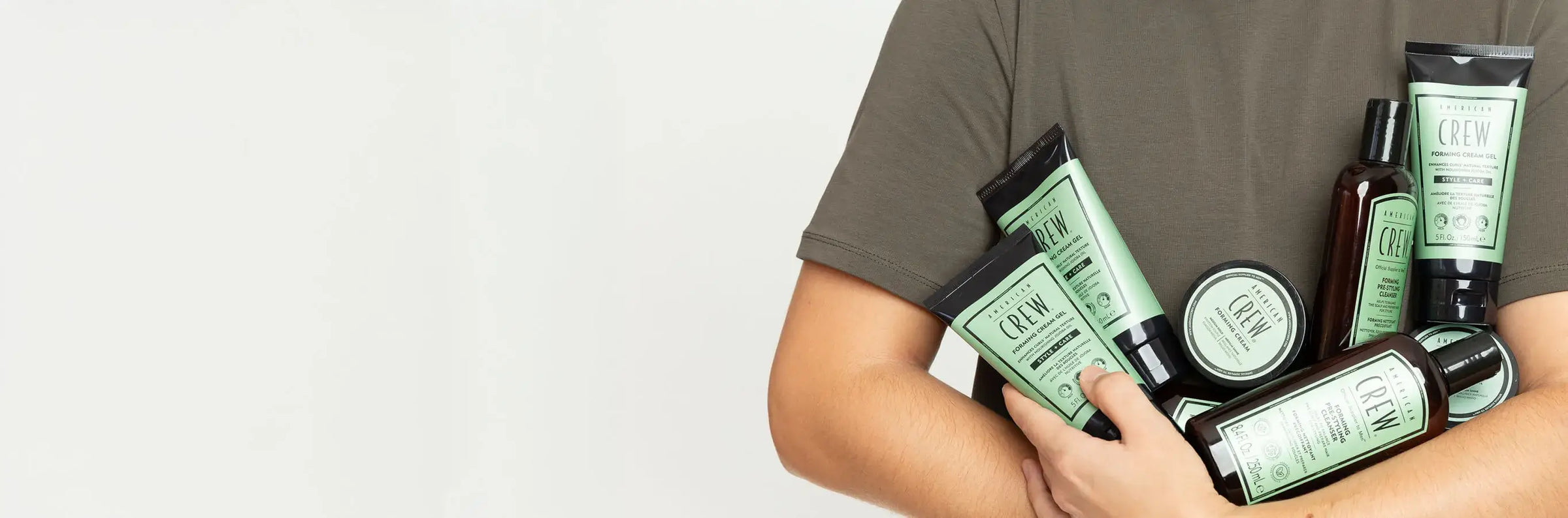 Man holding bottles of American Crew Forming Cream Gel, Forming Cream, and Forming Cream Pre-Styling Cleanser.