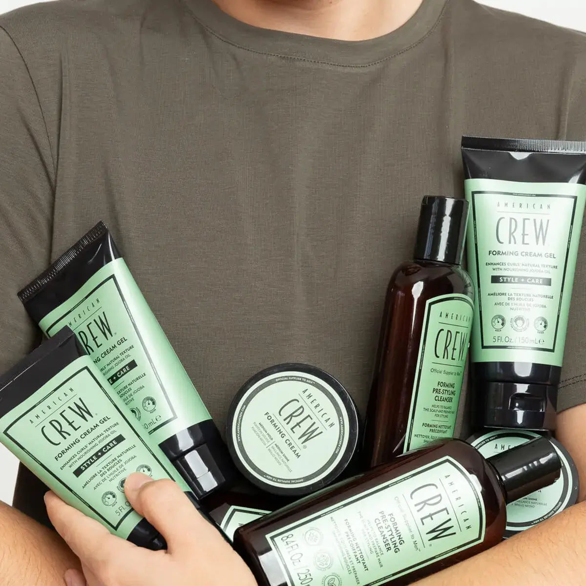 Man holding bottles of American Crew Forming Cream Gel, Forming Cream, and Forming Cream Pre-Styling Cleanser.