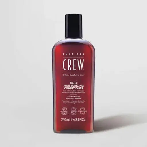 A bottle of American Crew Daily Moisturizing Conditioner, 250 mL, featuring a translucent dark red bottle and a black cap, set against a light gray background.