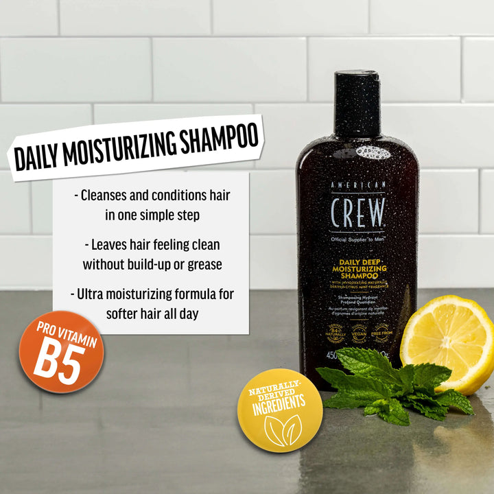 American Crew Daily Deep Moisturizing Shampoo bottle with lemon and mint leaves on a tiled background. Text callout says "Cleanses and conditions hair in one simple step. Leaves hair feeling clean without build-up or grease. Ultra moisturizing formula for softer hair all day". 