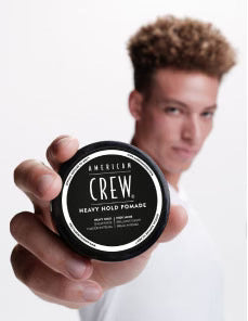 Model holding Heavy Hold Pomade Puck